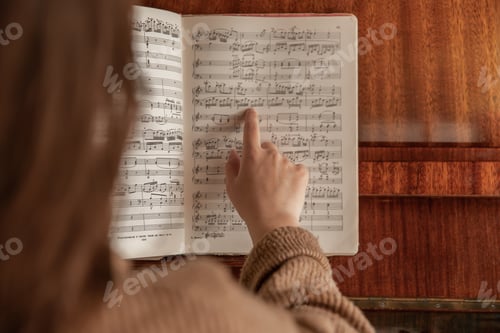 Preview: A woman shows her finger to the notes, the process of studying music.