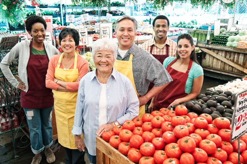 Preview: High angle view of group of men and women wearing aprons standing at stall with fresh tomatoes at a