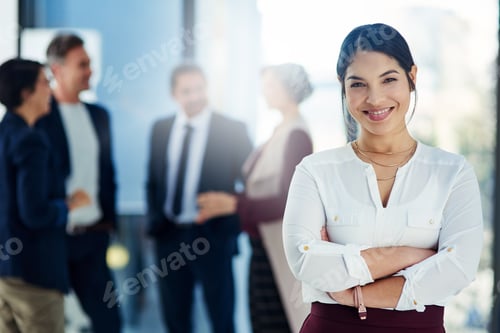 Preview: Cropped shot of a businesswoman standing with her arms crossed and her colleagues in the background