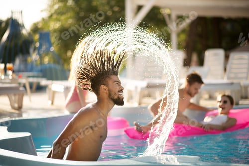 Preview: Bearded man with dreadlocks splashing water in pool