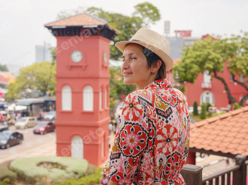 Preview: woman in dress and hat exploring vibrant streets of Malacca, Malaysia.