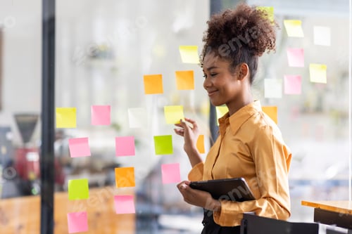Preview: Business female employee with many conflicting priorities arranging sticky notes commenting and