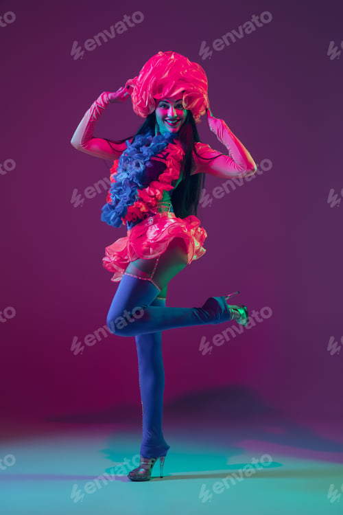Preview: Attractive hawaiian brunette model on purple studio background in neon light