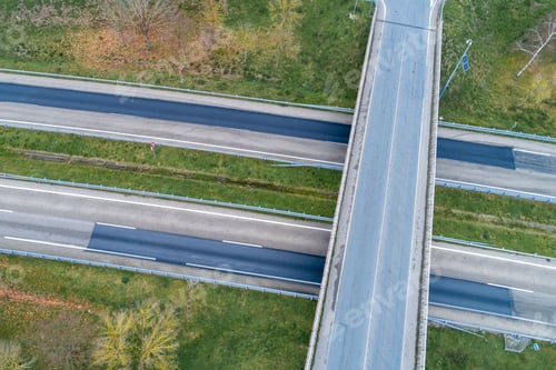 Preview: Aerial shot of a rural street intersection with no traffic, surrounded by lush green vegetation