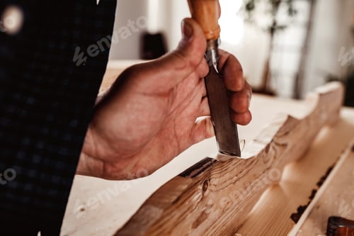 Preview: Hands of a carpenter working with chisel and hammer