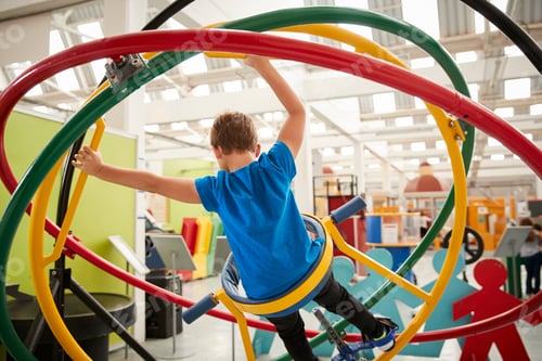 Preview: Young white boy using human gyroscope, back view