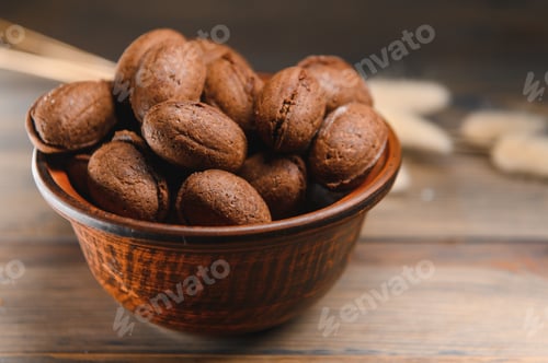 Preview: Delicious nut shaped cookies with boiled condensed milk on a wooden background