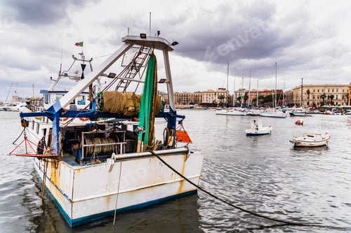 Preview: Bari, Italy - March 12, 2019: Old fishing boats moored to port dirty and in disuse.