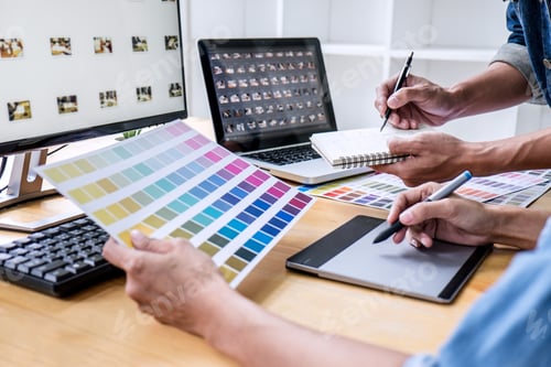 Preview: Two colleagues creative graphic designer working on color selection and drawing on graphics tablet