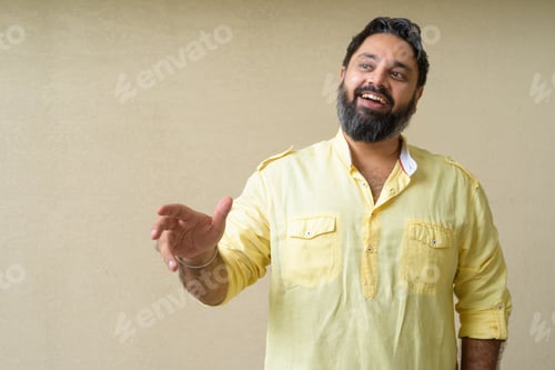 Preview: Portrait of handsome bearded Indian man against plain background