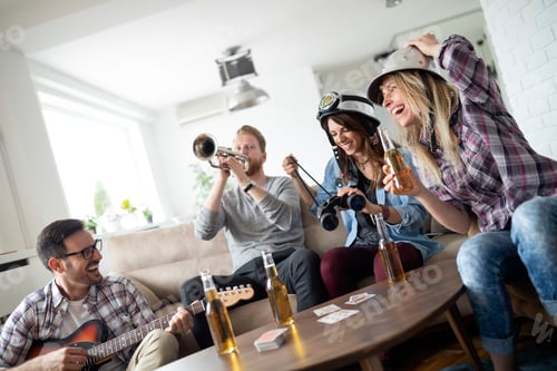 Preview: Group of friends at home enjoying singing and playing guitar