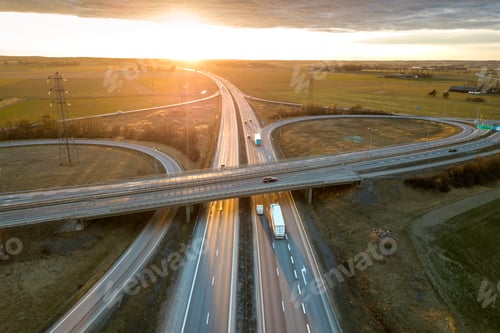 Preview: Aerial view of modern highway road intersection at dawn on rural landscape