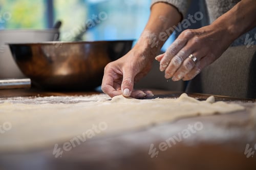 Preview: Low angle view of a woman preparing homemade pastry dough for a strudel or pie