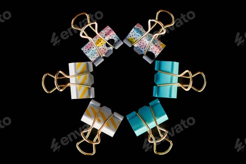 Preview: top view of yellow, blue and textured paper clips in circle isolated on black