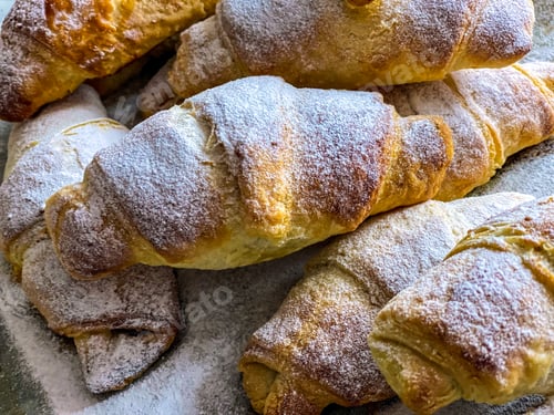 Preview: Homemade croissants sprinkled with powdered sugar.