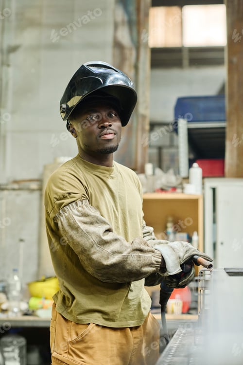 Preview: Industrial welder in protective uniform on workplace
