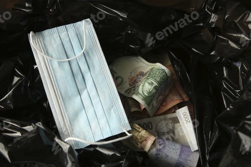 Preview: Money from around the world and a face mask inside a black plastic trash bag.