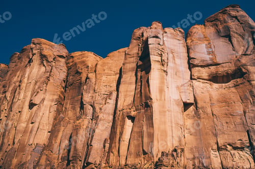 Preview: Steep cliff of tall rock against blue sky