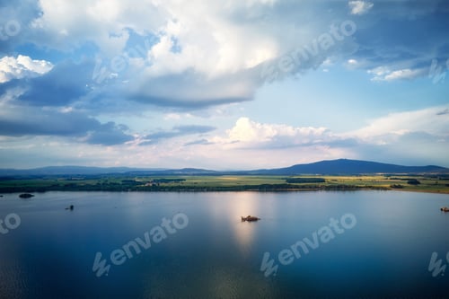 Preview: Flying drone over large lake with view of mountain peaks
