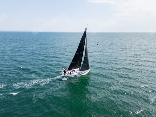 Preview: Sailing yacht with black sails cruising on open sea