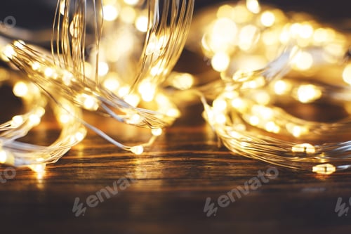 Preview: christmas beautifull shiny gold garland on a wooden brown background. sparkle festive background