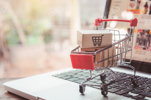 Preview: cardboard box with a shopping cart logo in a trolley on laptop keyboard.