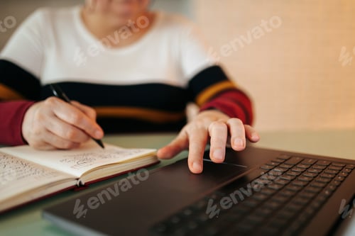 Preview: E-Student in Action Close-Up of a Woman Taking Notes on a Notebook While at Home