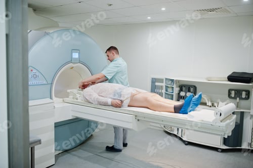 Preview: Male doctor turns on magnetic resonance imaging machine with patient inside.