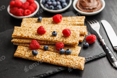Preview: Delicate crepes stacked with blueberries and raspberries, served with a chocolate spread.
