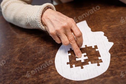 Preview: partial view of woman combing jigsaw puzzle as dementia therapy
