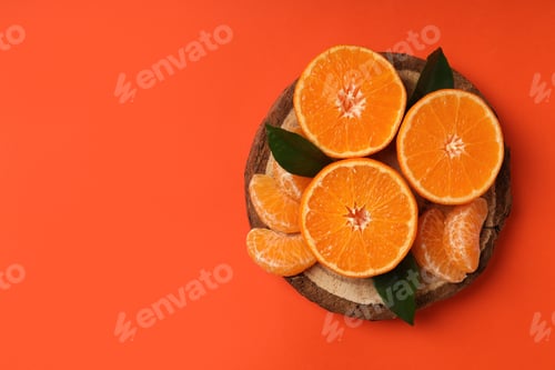 Preview: Board with mandarins with leaves on orange background