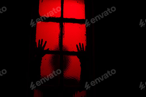 Preview: Silhouette of person leaning against window in room with red light