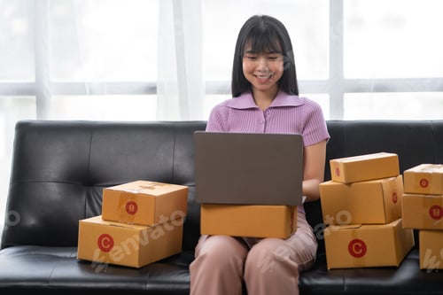 Preview: Asian women working SME business at the workplace at home. use laptop to check customer orders onlin