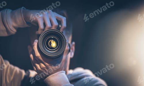 Preview: A man photographer with a camera takes a photo in the dark, copy space.