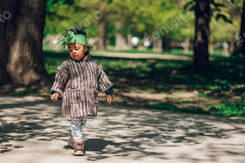 Preview: Little african american girl smiling and playing in the park