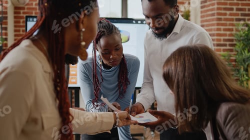 Preview: Close up of multi ethnic team working on business project