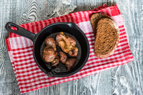 Preview: Top view roasted chicken giblets in pan and bread