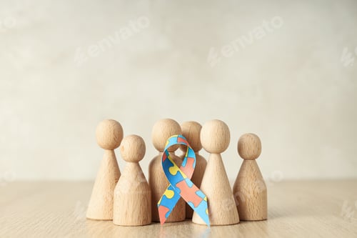 Preview: Ribbon with colorful puzzle pieces and wooden figures on light background. World autism day concept