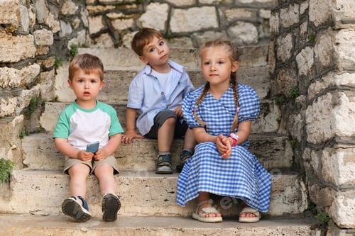 Preview: Cheerful children sit on the stairs