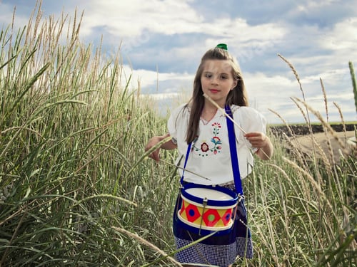 Preview: Girl playing with drums in wheat field