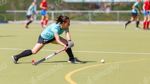 Preview: Young field hockey player hitting the ball during a match