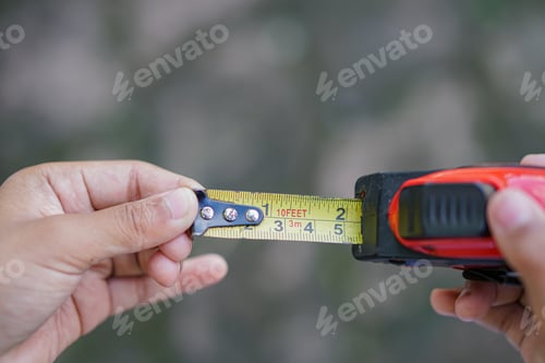 Preview: tape measuring in hand isolated on blurred background