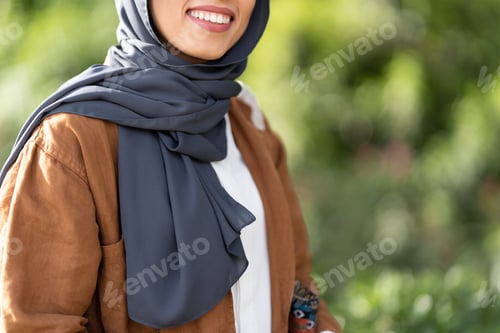 Preview: Smiling Woman Wearing a Hijab and Jacket Outdoors