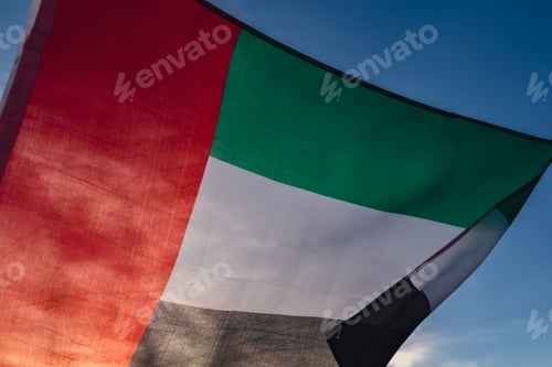 Preview: National Flag Of UAE Waving In The Wind sunset. Flag of United Arab Emirates on Sun Background. Sign