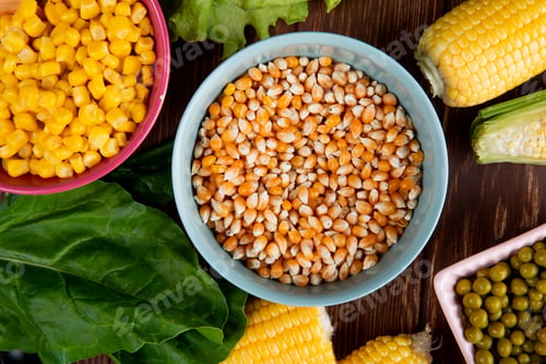 Preview: close-up view of bowl full of corn seeds with spinach, cooked corn seeds, green peas on wooden