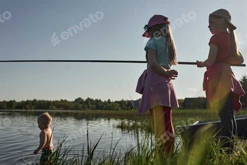 Preview: Children fishing on the shore of a large lake.