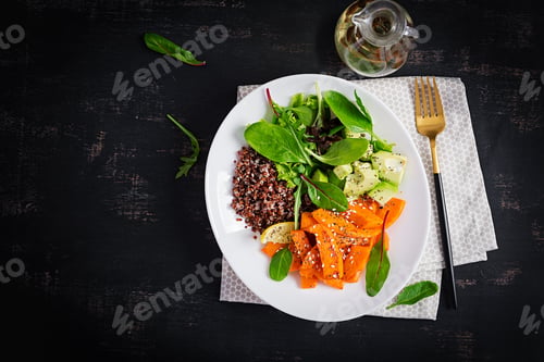 Preview: Buddha bowl with quinoa, fried sliced pumpkin, avocado and green herbs.