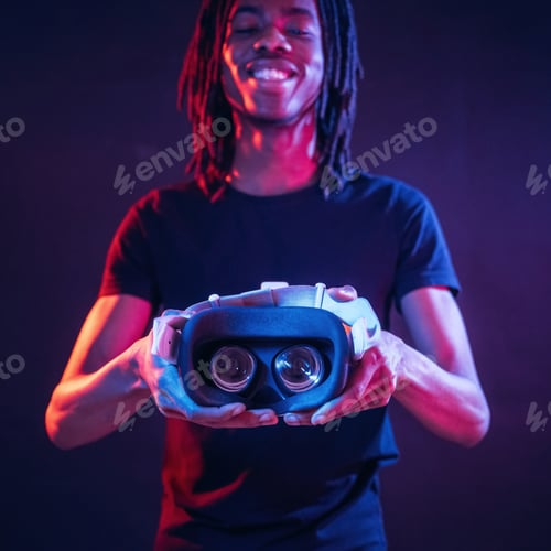 Preview: African American guy is with virtual reality glasses in neon room