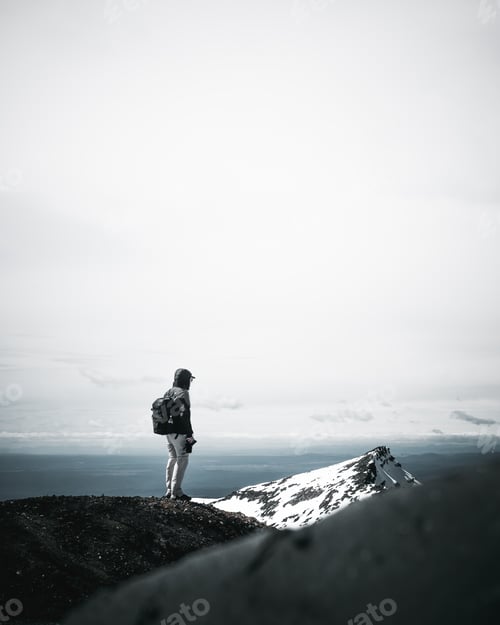 Preview: Vertical shot of a male traveler hiking on snowy mountains