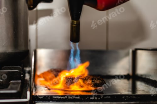 Preview: Some patties of ground meat with a flame with the blowtorch